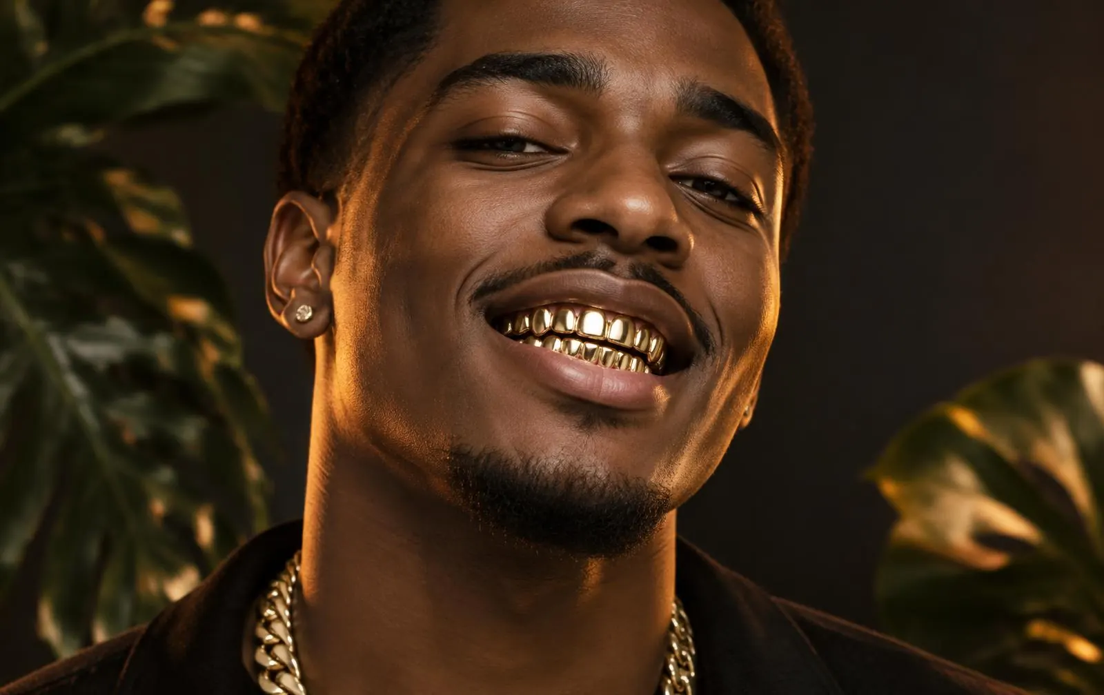 Sonrisa con grillz de oro amarillo pulido en los dientes superiores e inferiores, hechos a la medida en Medellín